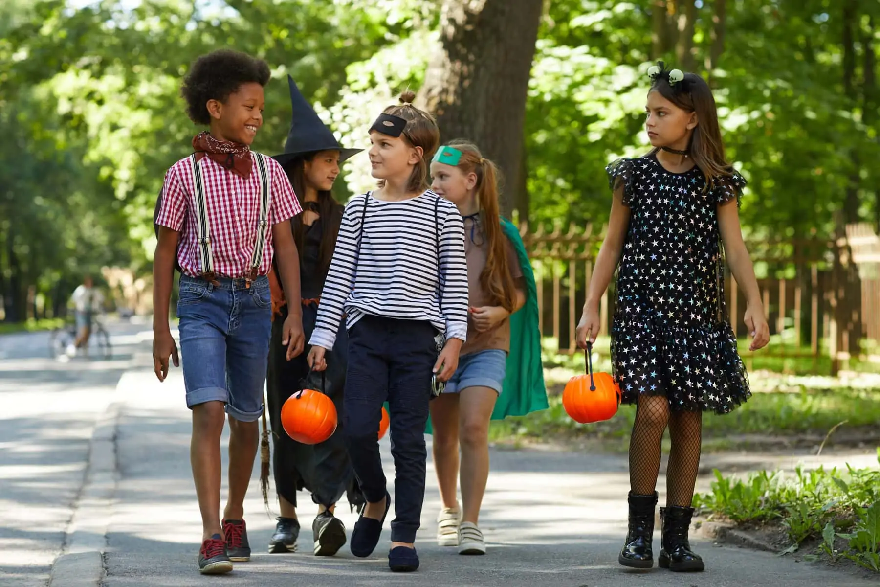 group-children-costumes-with-toy-pumpkins-walking-along-street-celebrate-sensory friendly halloween