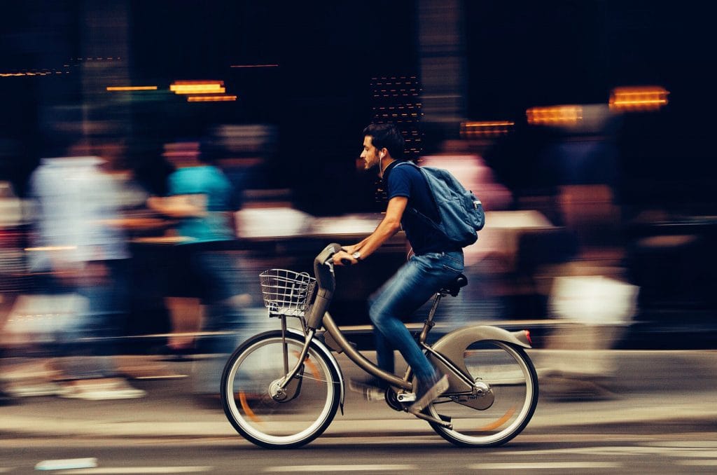 Young man biking through urban city.