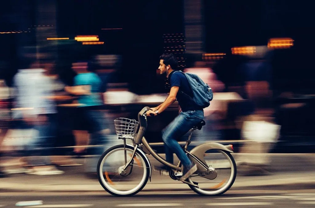 Young person biking through urban city.