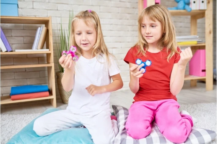 Two young people playing with fidget sensory friendly toys.