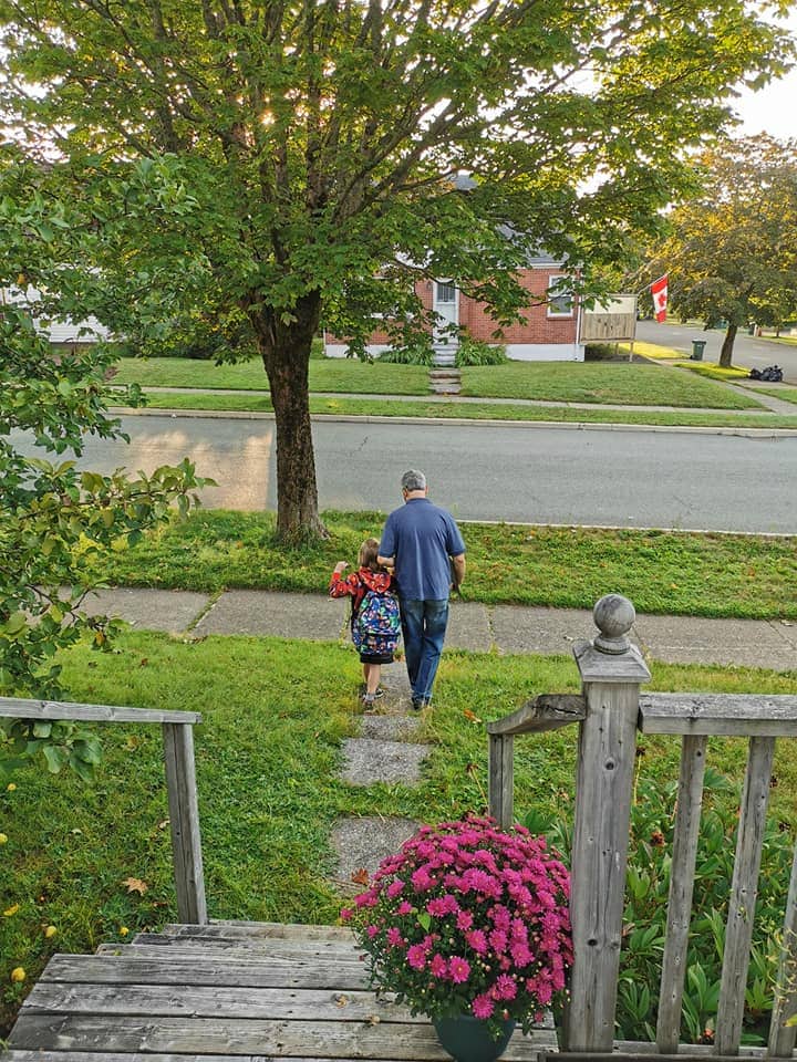 Young boy and day walking down path away from house