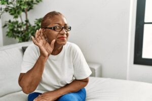 Older adult cupping their ear