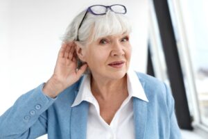 Older woman cupping her ear.