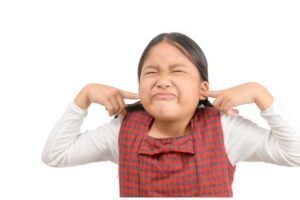 Young Asian person plugging their ears.