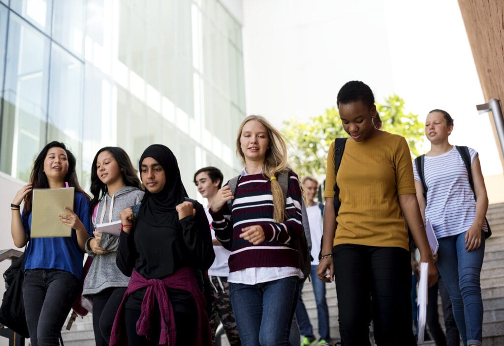 Diverse group of students walking in school down staircase.