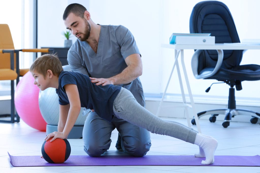 Child playing with sensory friendly ball with adult.