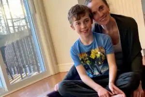 Lindsay Hall and young boy sitting on yoga mat.