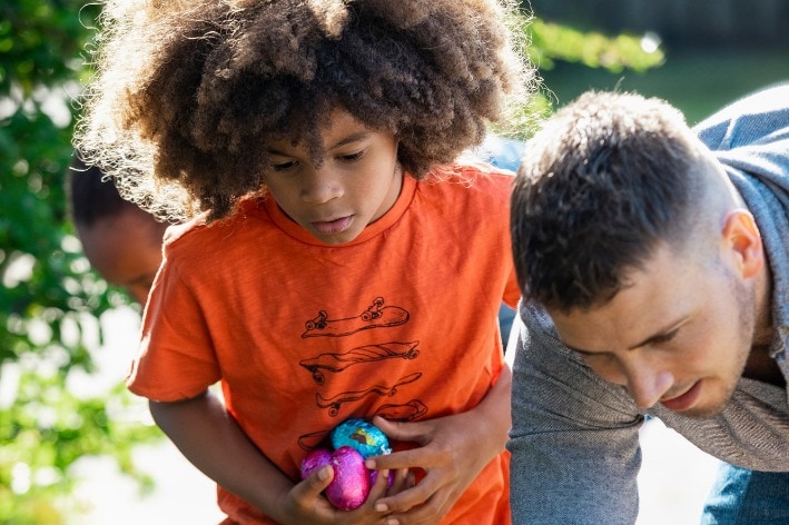 Boy holding eggs on a sensory-friendly Easter egg hunt