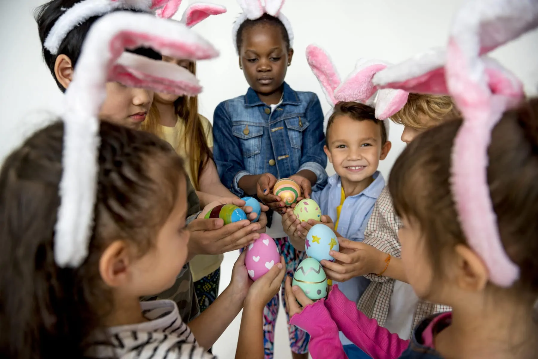 Group of kids on Easter holding Easter eggs.
