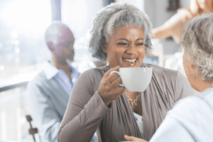 Two senior women sitting at a coffee shop.