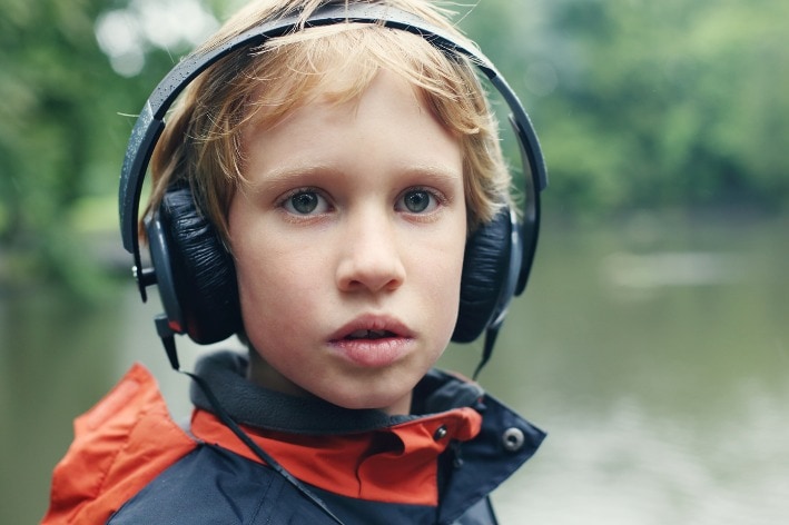 Young boy wearing noise-cancelling ear muffs.