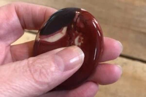 Woman's hand holding a brown focus stone.