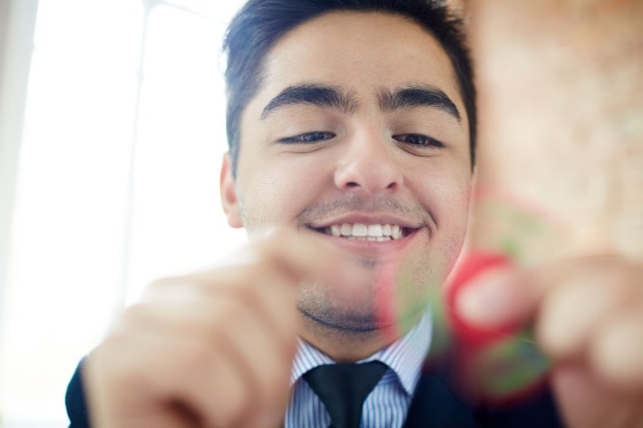 Young man playing with fidget spinner.