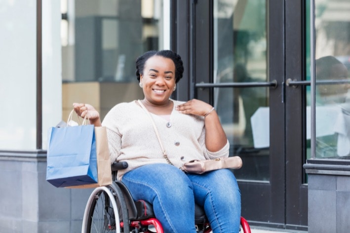 Woman in wheelchair shopping at sensory-friendly business.