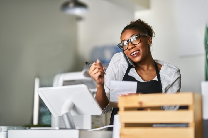 Woman on the phone while running her sensory-friendly business.