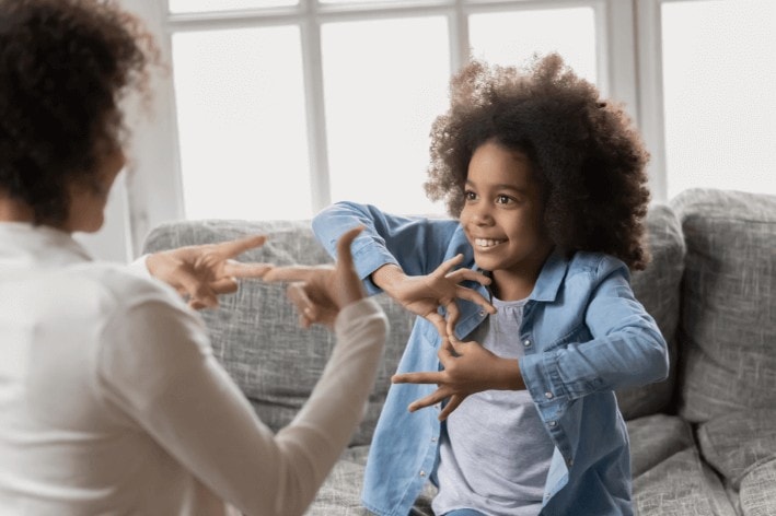 Adult and young child learning sign language.