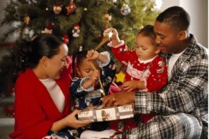 Family on Christmas morning unwrapping presents.