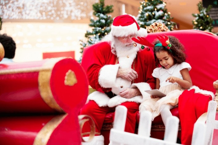 Child sitting beside Sensitive Santa
