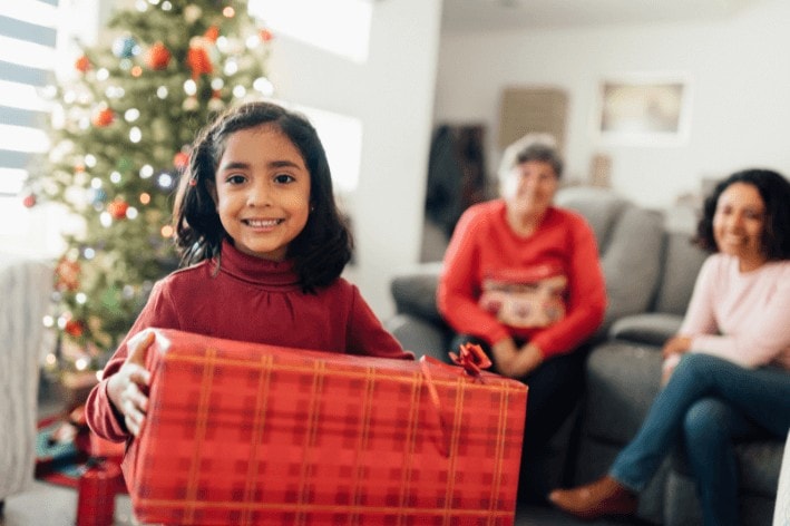 Young person smiling holding a present.