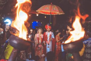Two Hindu couples walking down the aisle with people surrounding them at a sensory-friendly Hindu wedding.
