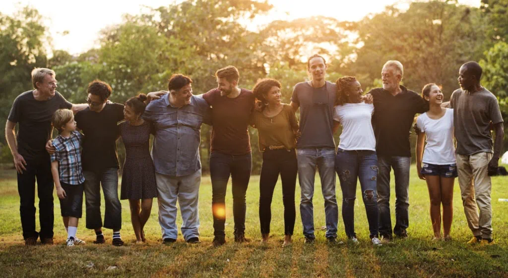 group of multiethnic people standing with their arms around each other