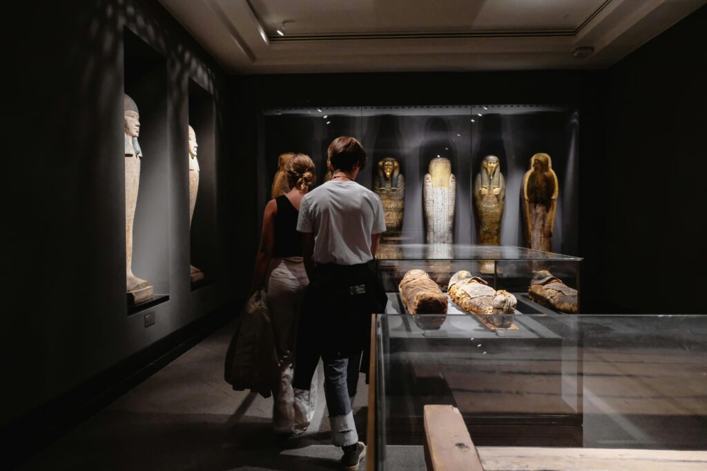 Youth walking through an Egyptian mummy exhibit at a museum