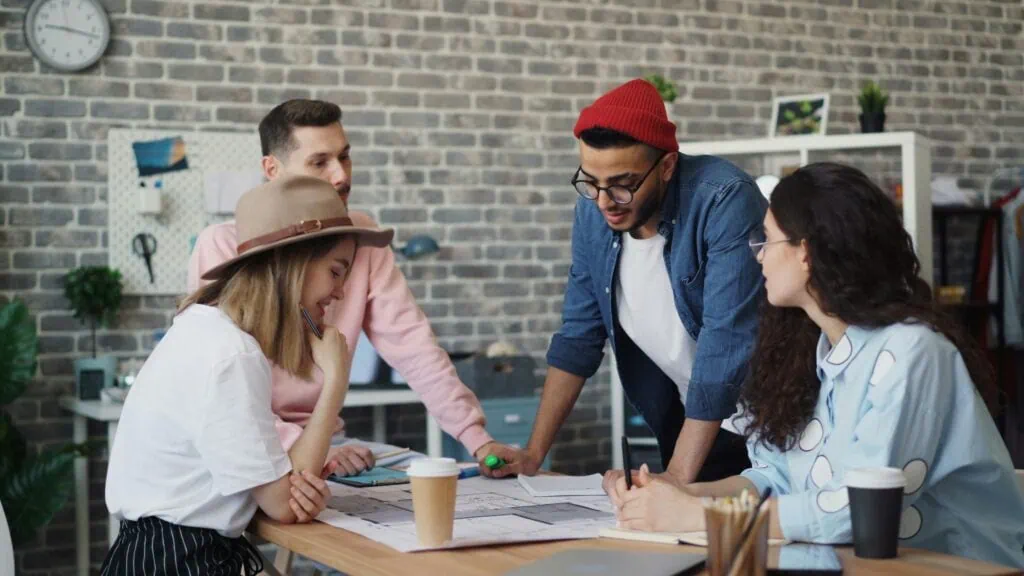 group of four diverse people at a table planning a sensory-friendly experience